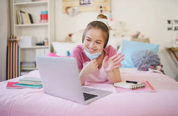 Jonge studente met laptop op bed, online lesconcept. — Stockfoto