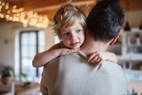Father carrying small sick unhappy son indoors at home, comforting him. — Stock Photo, Image