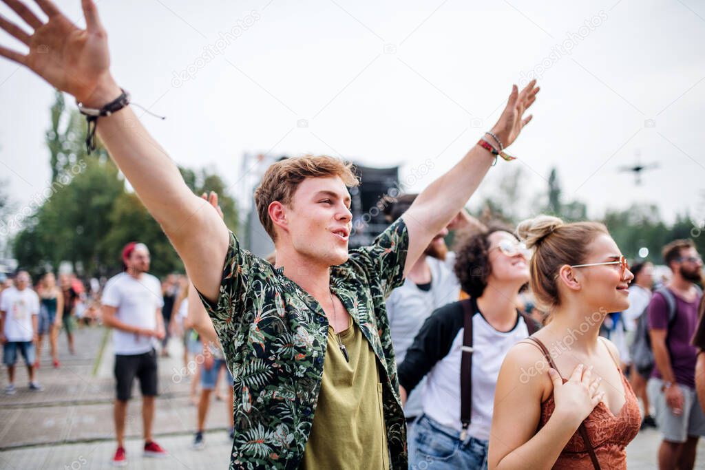 Group of young friends at summer festival, dancing.