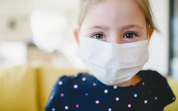 Niña con mascarillas en casa, virus Corona y concepto de cuarentena . — Foto de Stock