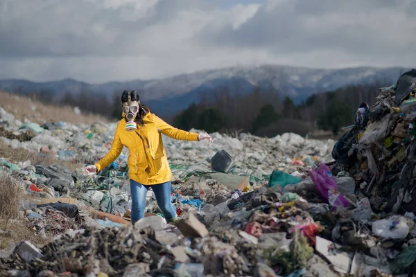 Donna con maschera antigas che cammina sulla discarica, concetto ambientale . — Foto Stock