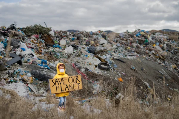 Small child holding placard poster on landfill, environmental pollution concept. — Stock Photo, Image