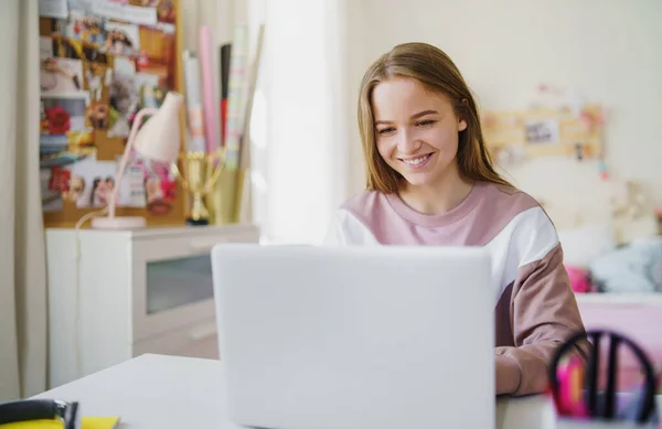 Jovem estudante sentada à mesa, usando laptop em quarentena . — Fotografia de Stock