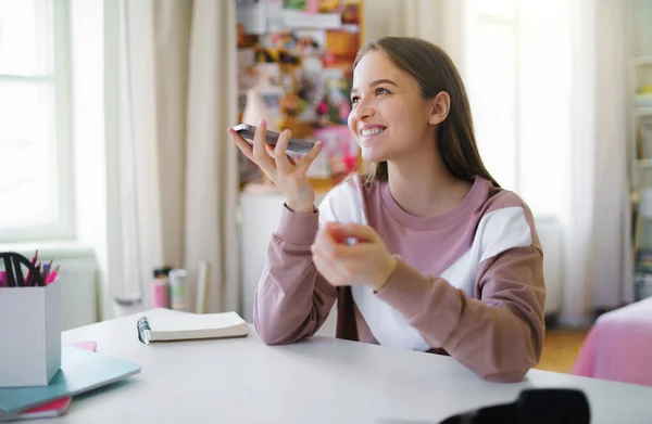 Young female student with smartpone at the table, online lesson concept. — Stock Photo, Image
