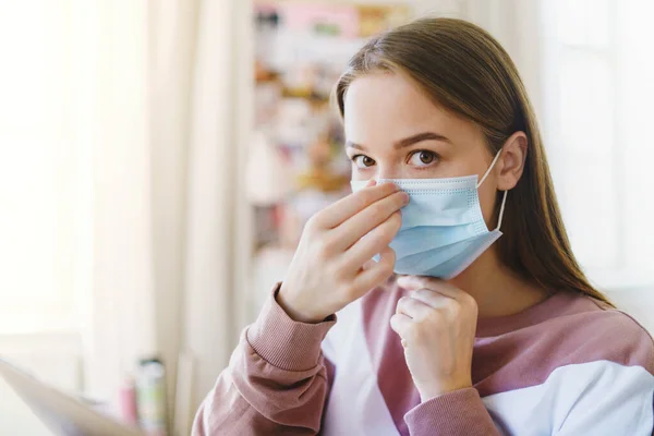 Jonge studente met gezichtsmasker binnen, kijkend naar camera. — Stockfoto