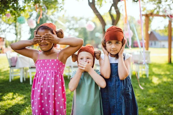 Μικρά παιδιά με μάσκες σε εξωτερικούς χώρους για πάρτι στον κήπο το καλοκαίρι, παίζοντας. — Φωτογραφία Αρχείου