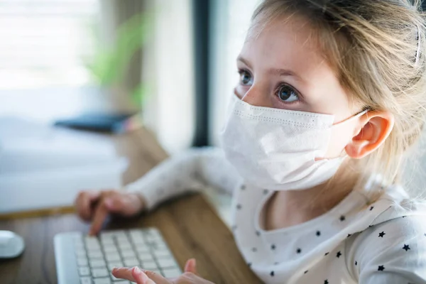 집에 있는 컴퓨터를 사용하는 어린 소녀, 코로나 바이러스와 격리 개념. — 스톡 사진