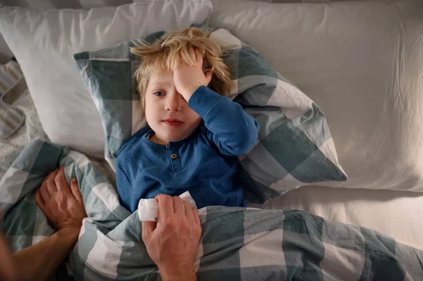 Baba evde yatağında yatan küçük hasta çocuğu kontrol ediyor.. — Stok fotoğraf