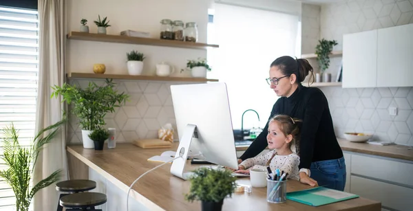 Woman with small daughter working indoors at home office. — Stock Photo, Image