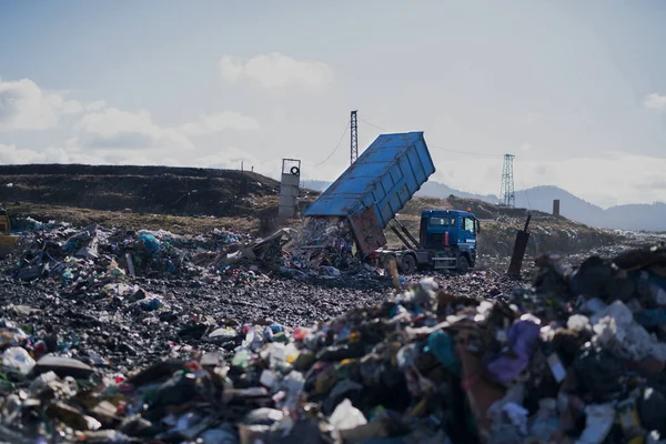Śmieciarka rozładowująca odpady na składowisku, koncepcja środowiskowa. — Zdjęcie stockowe