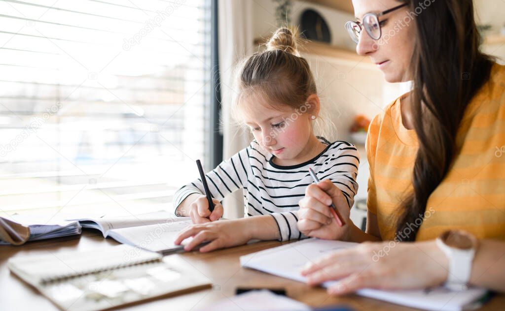 Mother and daughter learning indoors at home, Corona virus and quarantine concept.