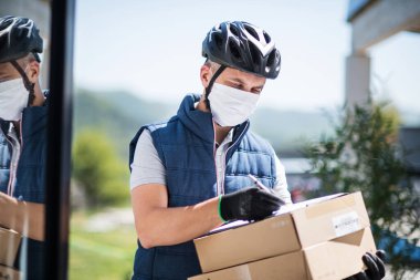 Yüzü maskeli kurye paket, korona virüsü ve karantina konsepti getiriyor..