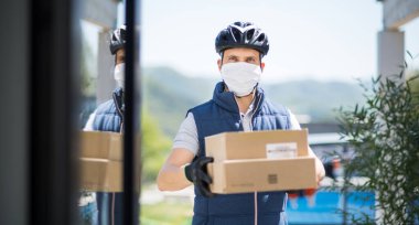 Yüzü maskeli kurye paket, korona virüsü ve karantina konsepti getiriyor..
