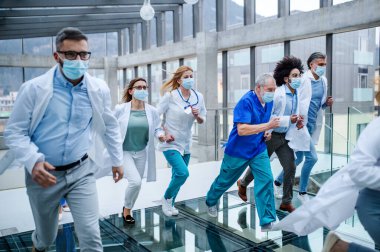 Hastane koridorunda koşan bir grup doktor, acil durum kavramı..