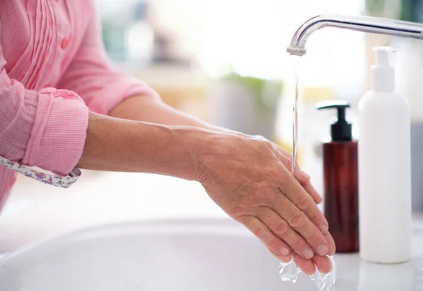 Невпізнавана жінка миє руки вдома, концепція вірусу корони . — стокове фото