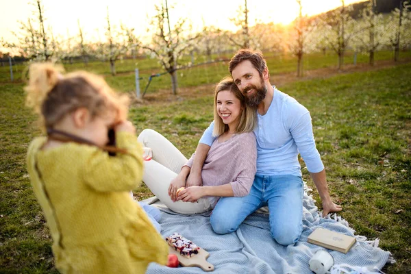 Malá dívka s fotoaparátem fotografování na rodinném pikniku venku v přírodě. — Stock fotografie