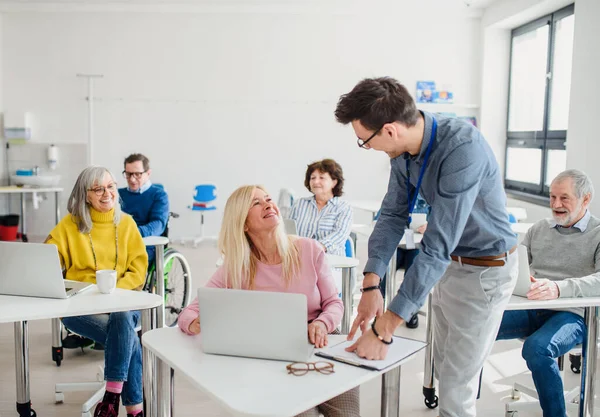 Gruppo di persone anziane che frequentano corsi di informatica e tecnologia . — Foto Stock