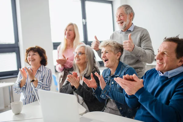 Groep vrolijke senioren die computer- en technologieonderwijs volgen. — Stockfoto