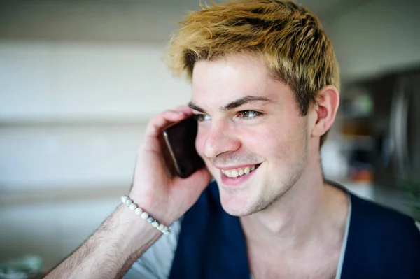 Close-up of young man with smartphone indoors at home, making phone call. — Stock Photo, Image