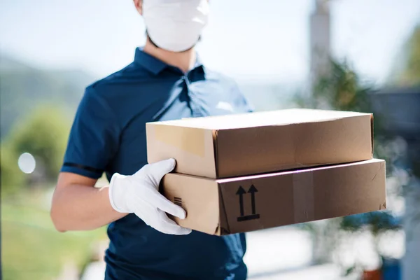 Unrecognizable courier with face mask delivering parcel, corona virus and quarantine concept. — Stock Photo, Image