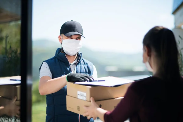 Yüzü maskeli kurye paket, korona virüsü ve karantina konsepti getiriyor.. — Stok fotoğraf