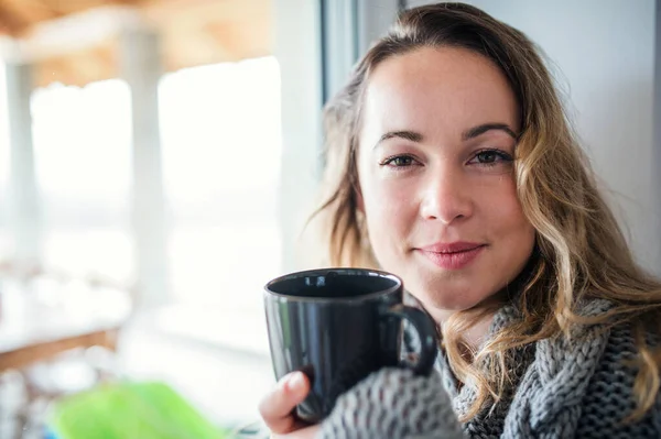 Young woman relaxing indoors at home with cup of coffee or tea. — Stockfoto