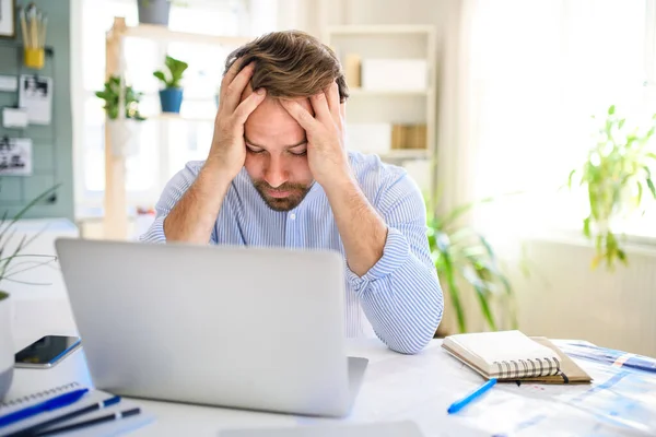 Homme d'affaires mature frustré avec ordinateur portable à l'intérieur dans le bureau à domicile, travaillant . — Photo