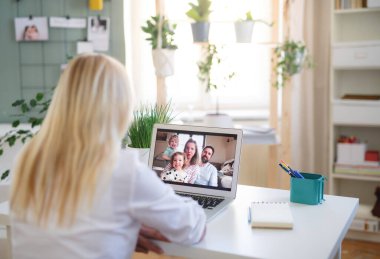 Evde dizüstü bilgisayarı olan yaşlı bir kadın, aile video araması konsepti..