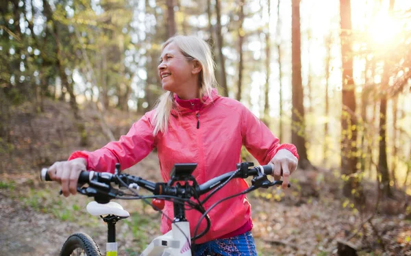 Mulher idosa ativa com e-bike ciclismo ao ar livre na natureza . — Fotografia de Stock