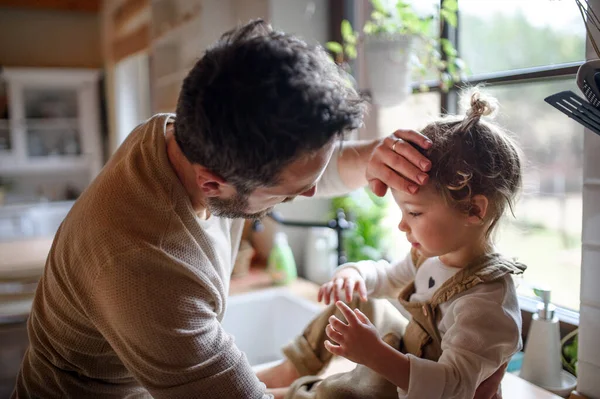 Vater prüft Stirn kranker Kleinkind-Tochter zu Hause. — Stockfoto