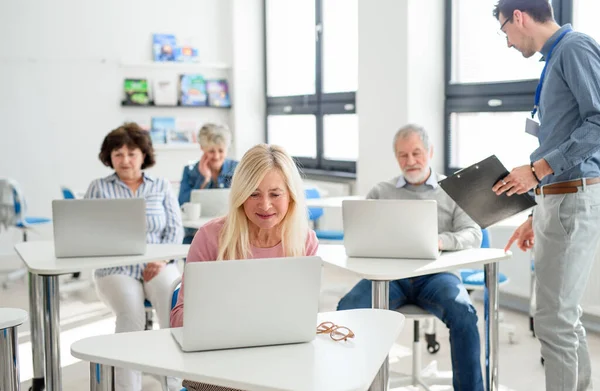 Gruppo di persone anziane che frequentano corsi di informatica e tecnologia . — Foto Stock