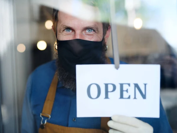 Propietario de cafetería con máscara facial, abierto después de la cuarentena de bloqueo . — Foto de Stock