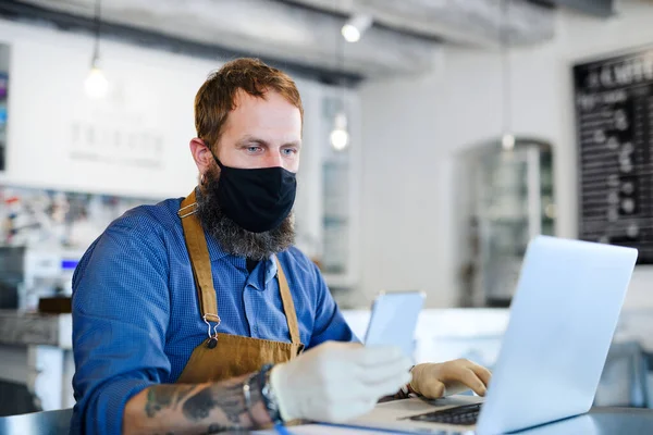 Coffee shop man owner working with face mask, open after lockdown quarantine. — Stock Photo, Image