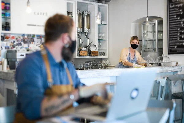 Propietarios de cafetería que trabajan con máscaras faciales, abiertas después de la cuarentena de cierre . — Foto de Stock