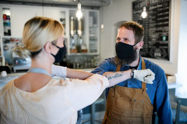 Propietarios de cafetería con máscaras faciales codo golpeando, abierto después de la cuarentena de bloqueo . — Foto de Stock