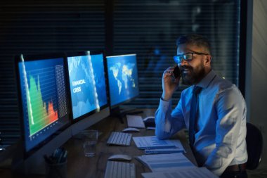 Bilgisayarlı bir iş adamı geç saatlere kadar çalışıyor. Mali kriz kavramı.