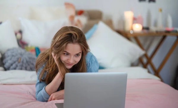 漂亮而快乐的小女孩，坐在笔记本电脑前，面带微笑，网上约会的概念. — 图库照片
