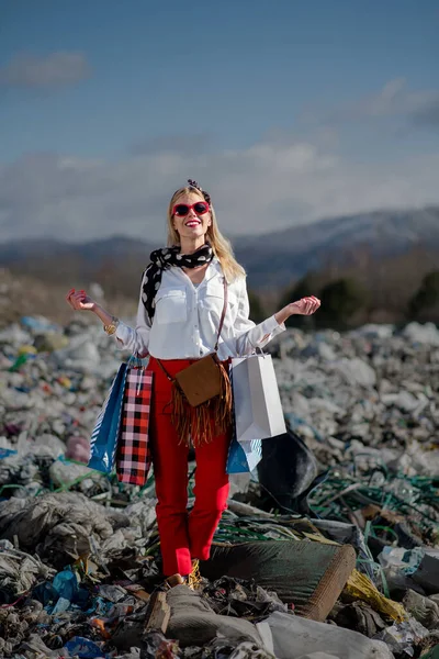 Femme moderne en décharge, concept de consumérisme contre pollution . — Photo