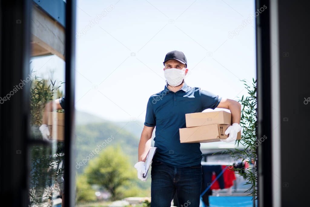 Courier with face mask delivering parcel, corona virus and quarantine concept.