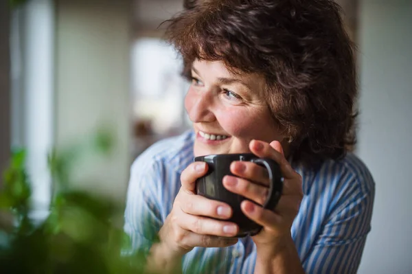 Senior kvinna med kopp kaffe hemma, avkopplande. — Stockfoto