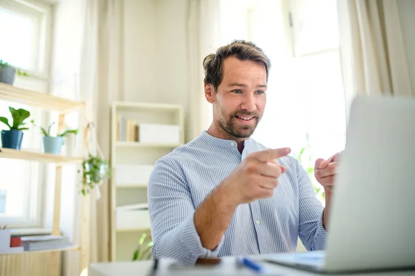 Volwassen zakenman met videogesprek op laptop thuis. — Stockfoto