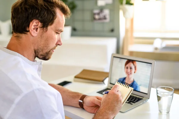 Hombre que tiene videollamada con el médico en el ordenador portátil en casa, concepto de consulta en línea . — Foto de Stock