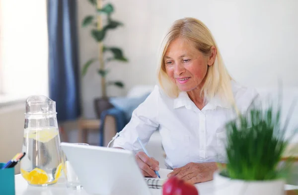 Aantrekkelijke senior zakenvrouw met laptop binnen in kantoor, werken. — Stockfoto