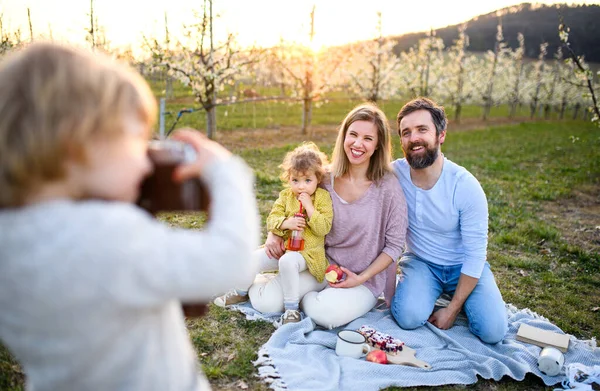 自然の中で屋外で家族のピクニックで写真を撮るカメラを持つ小さな男の子. — ストック写真
