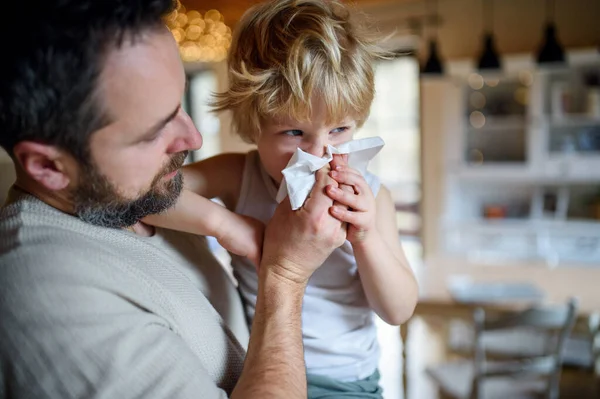 Vater pustet kleinen kranken Sohn zu Hause in die Nase. — Stockfoto