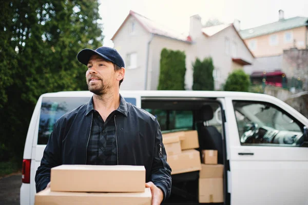 Framifrån av leverans man kurir leverera paket låda i stan. — Stockfoto