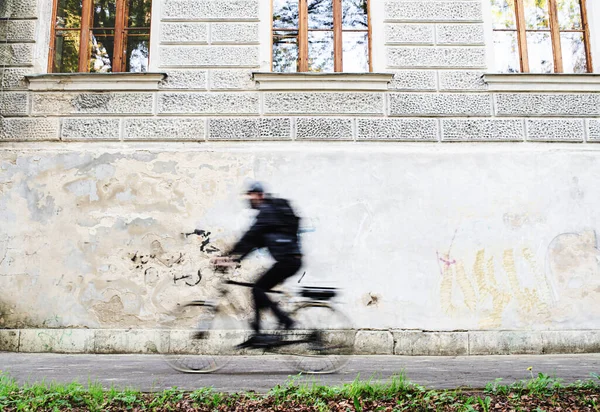 Entrega mensajero hombre con máscara facial y ciclismo en bicicleta en la ciudad . — Foto de Stock