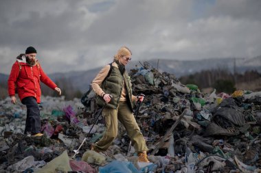 Man and woman hikers on landfill, environmental concept. clipart