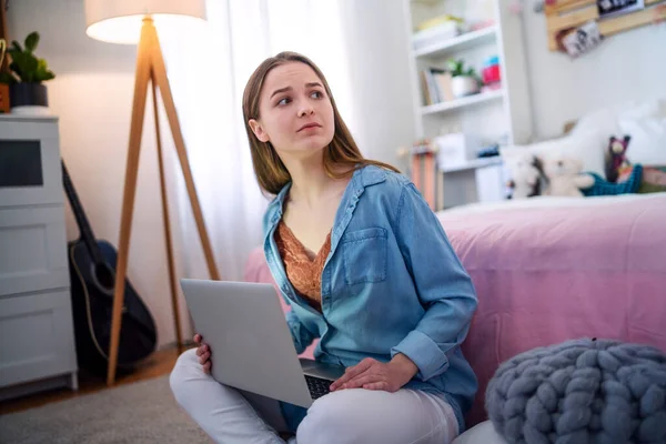 Triest en bezorgd jong meisje met laptop binnen zitten, internet misbruik concept. — Stockfoto