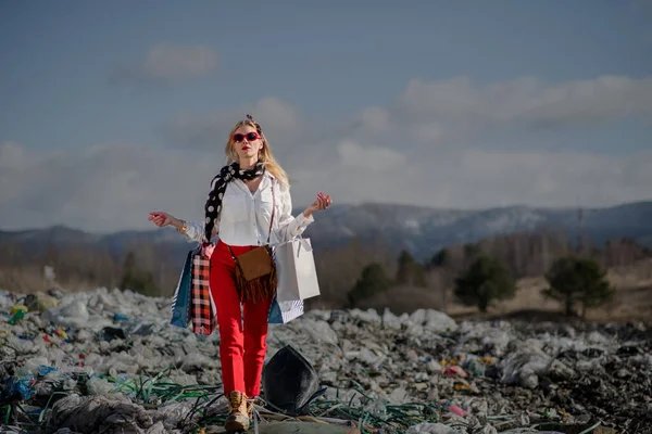 Çöp sahalarında alışveriş torbaları olan kadın, tüketime karşı kirlilik kavramı. — Stok fotoğraf